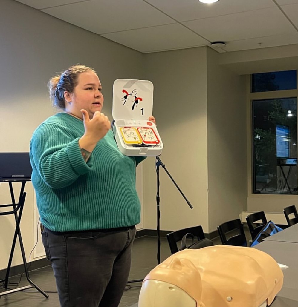 Hannah Taylor holding AED equipment during a demonstration