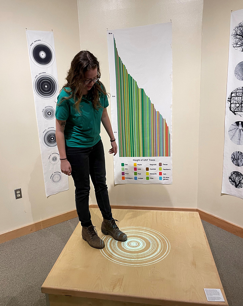 Student standing on platform showing her tree survey data