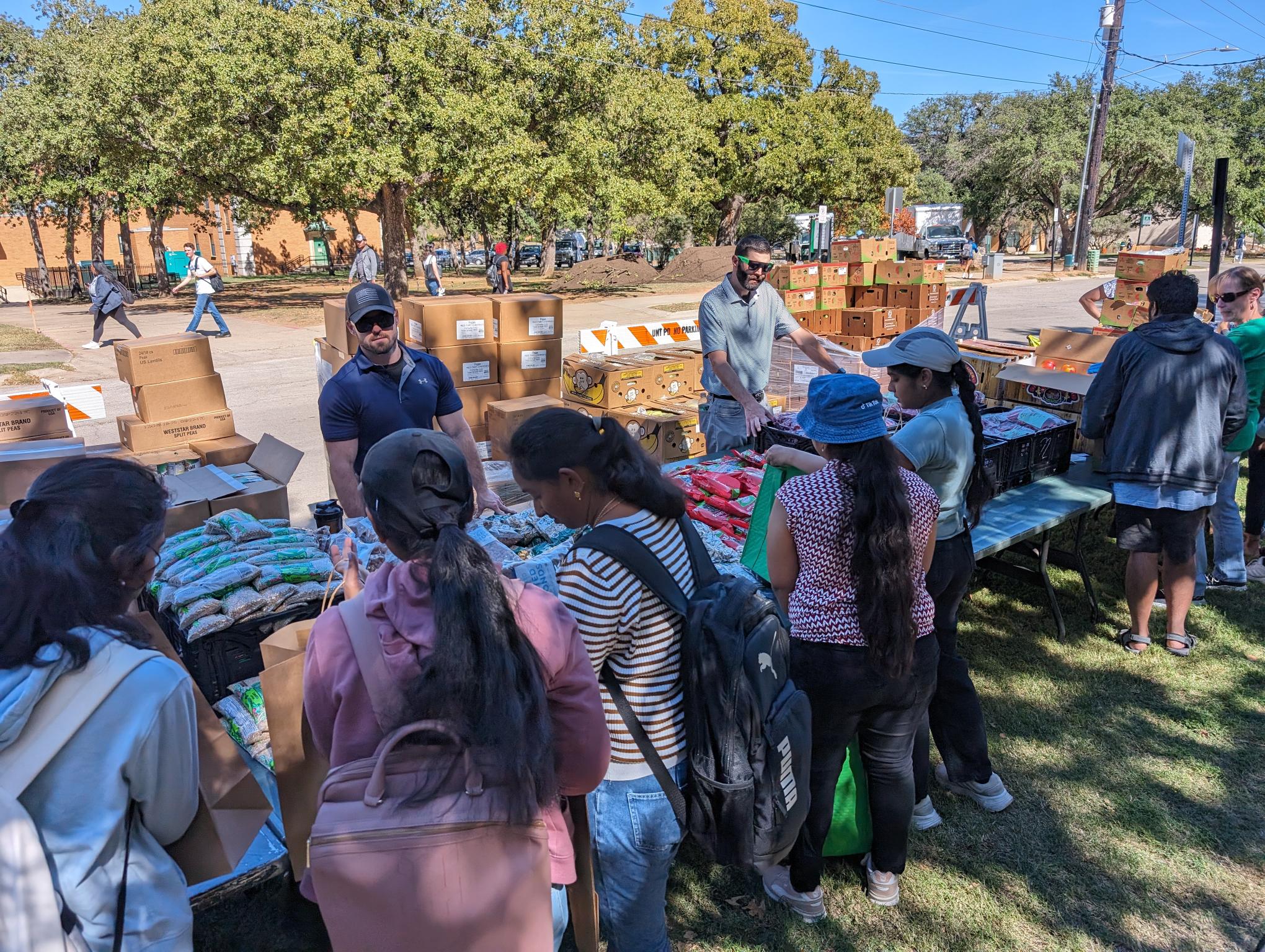 Two officer recruits behind a table handing out food