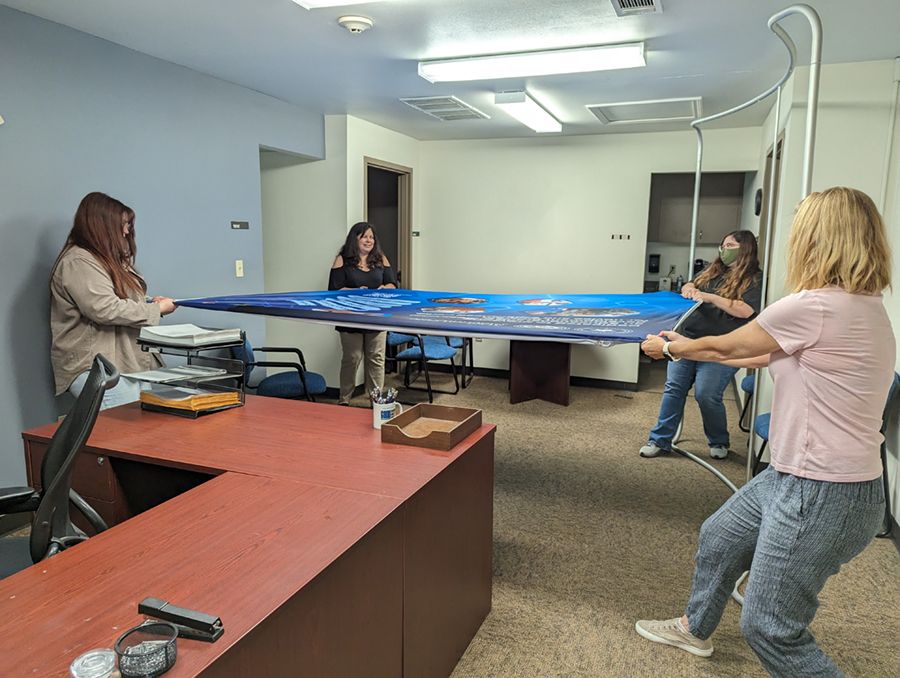 three employees holding a banner