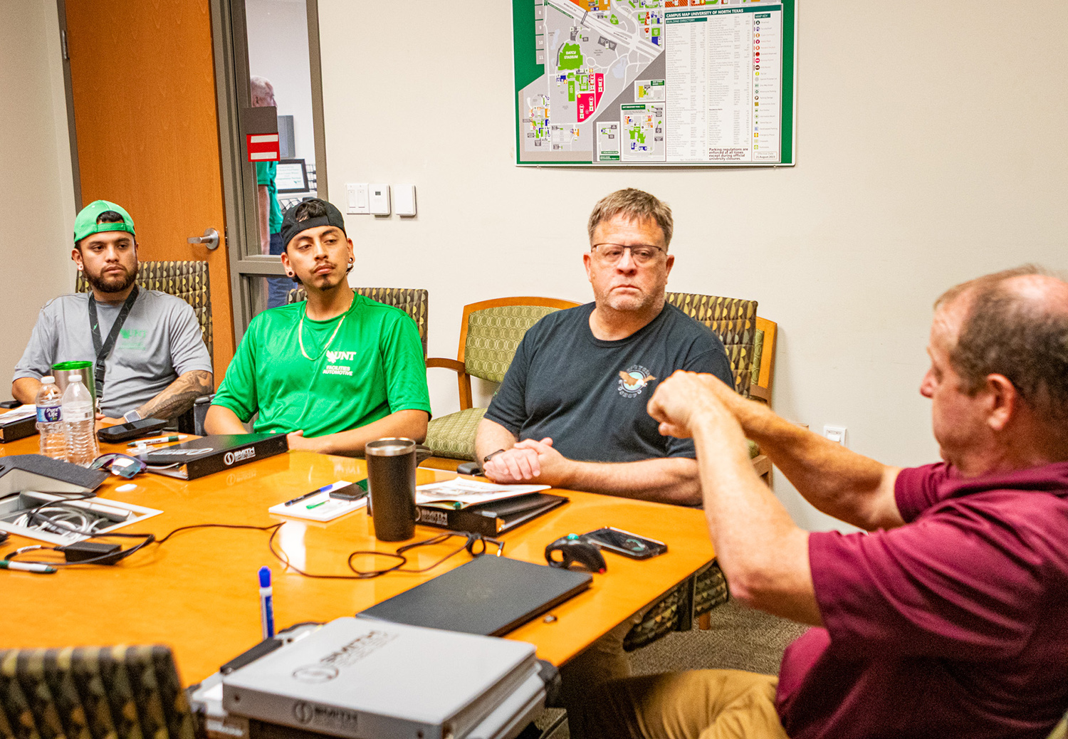 A session leader gestures as three staff members look on.