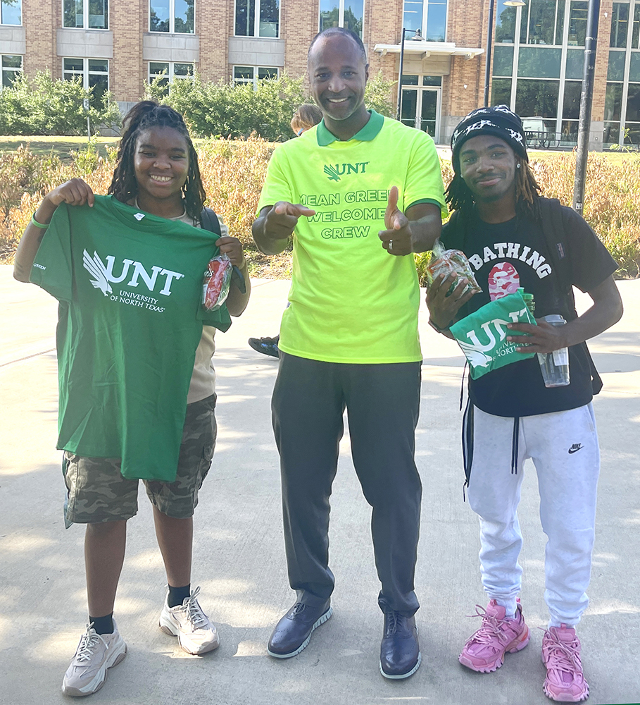 Vice president Clayton Gibson stands with two students