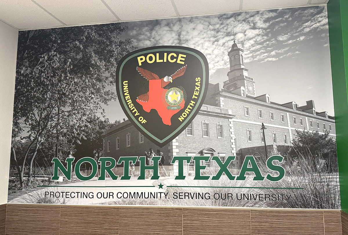 Mural depicting the UNT Police patch overlaid on an image of the Hurley Administration Building