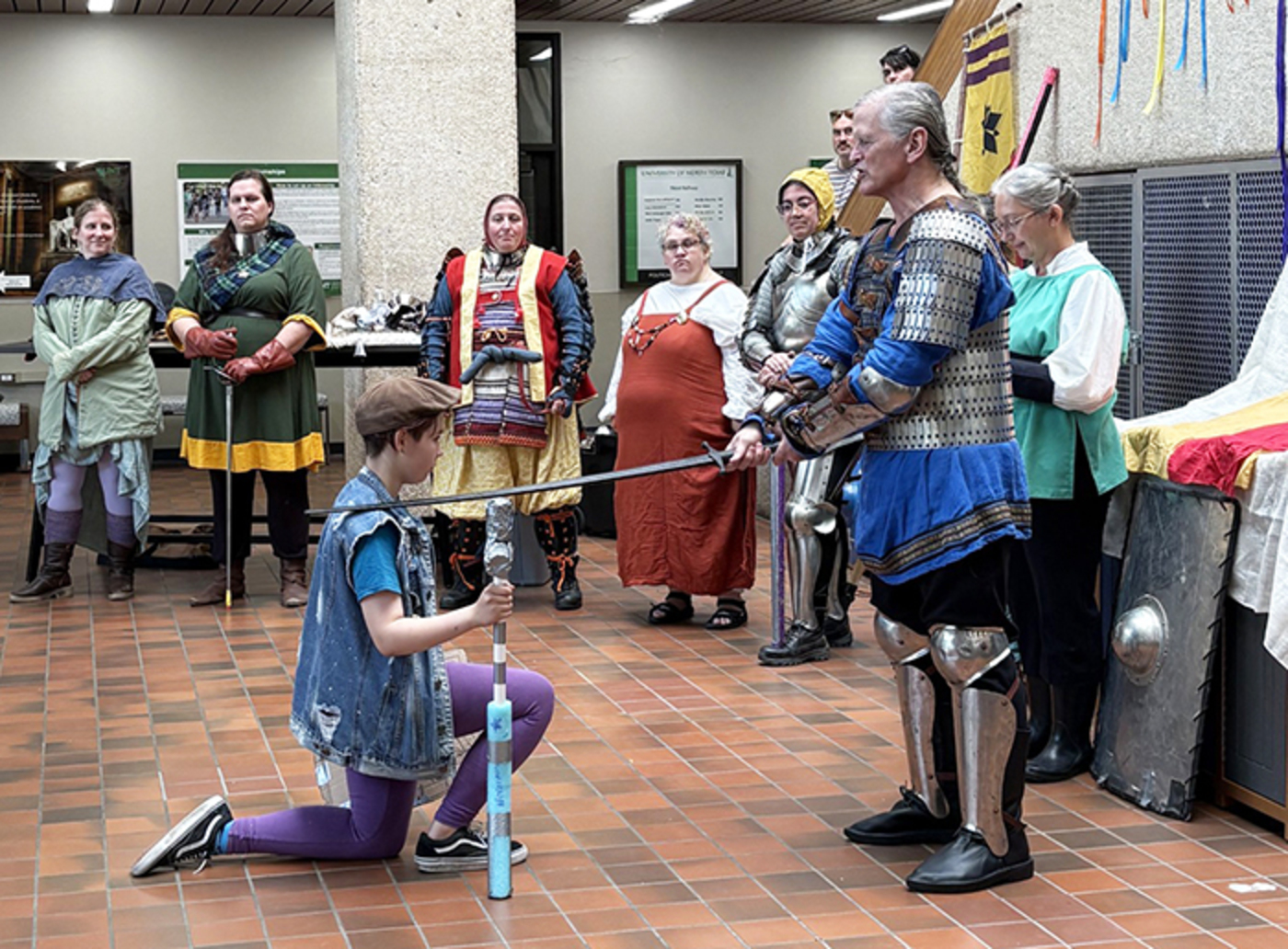 Doug Turnage, dressed as a knight, proceeds to successfully knight a camp participant