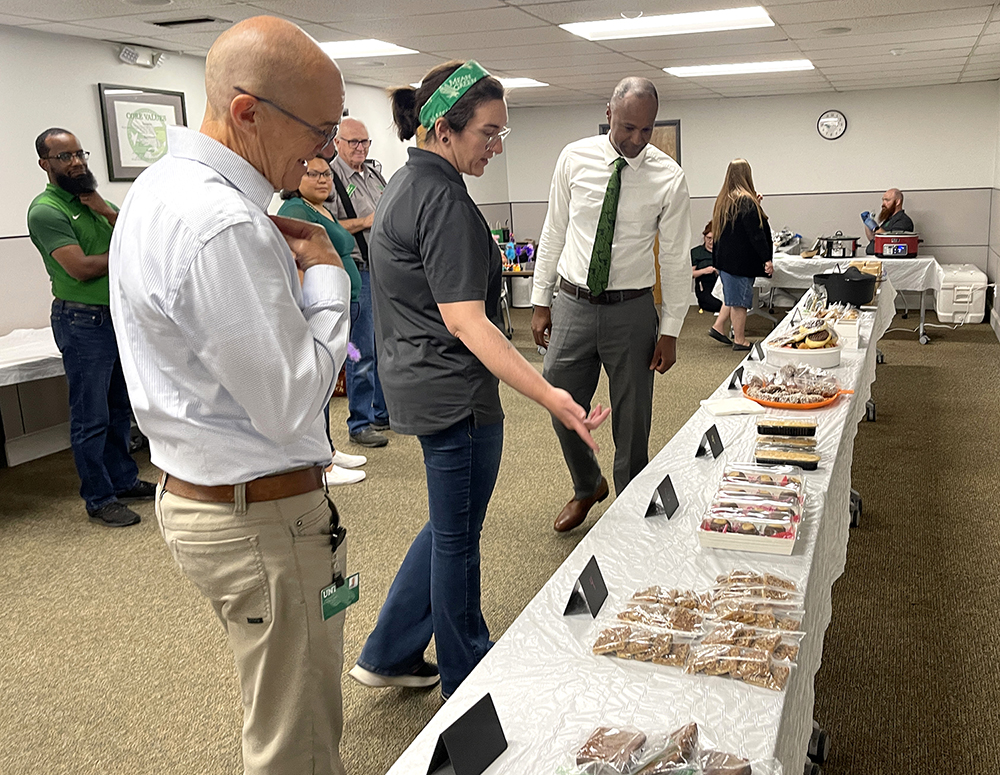 Vice President Clayton Gibson and staff members look at baked goods for sale