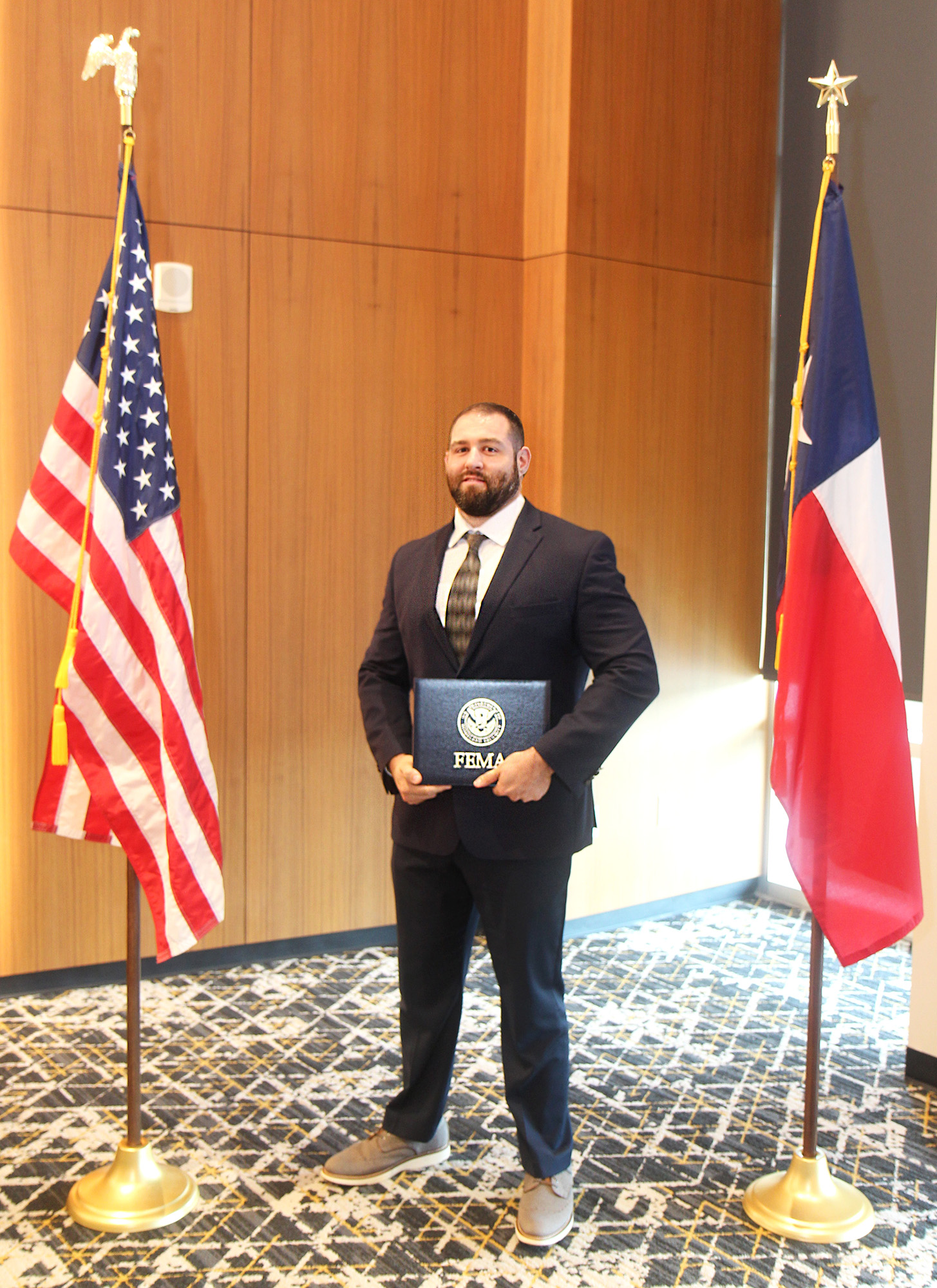 Associate Director of Emergency Management & Planning Corey Olszewski holding his graduation certificate