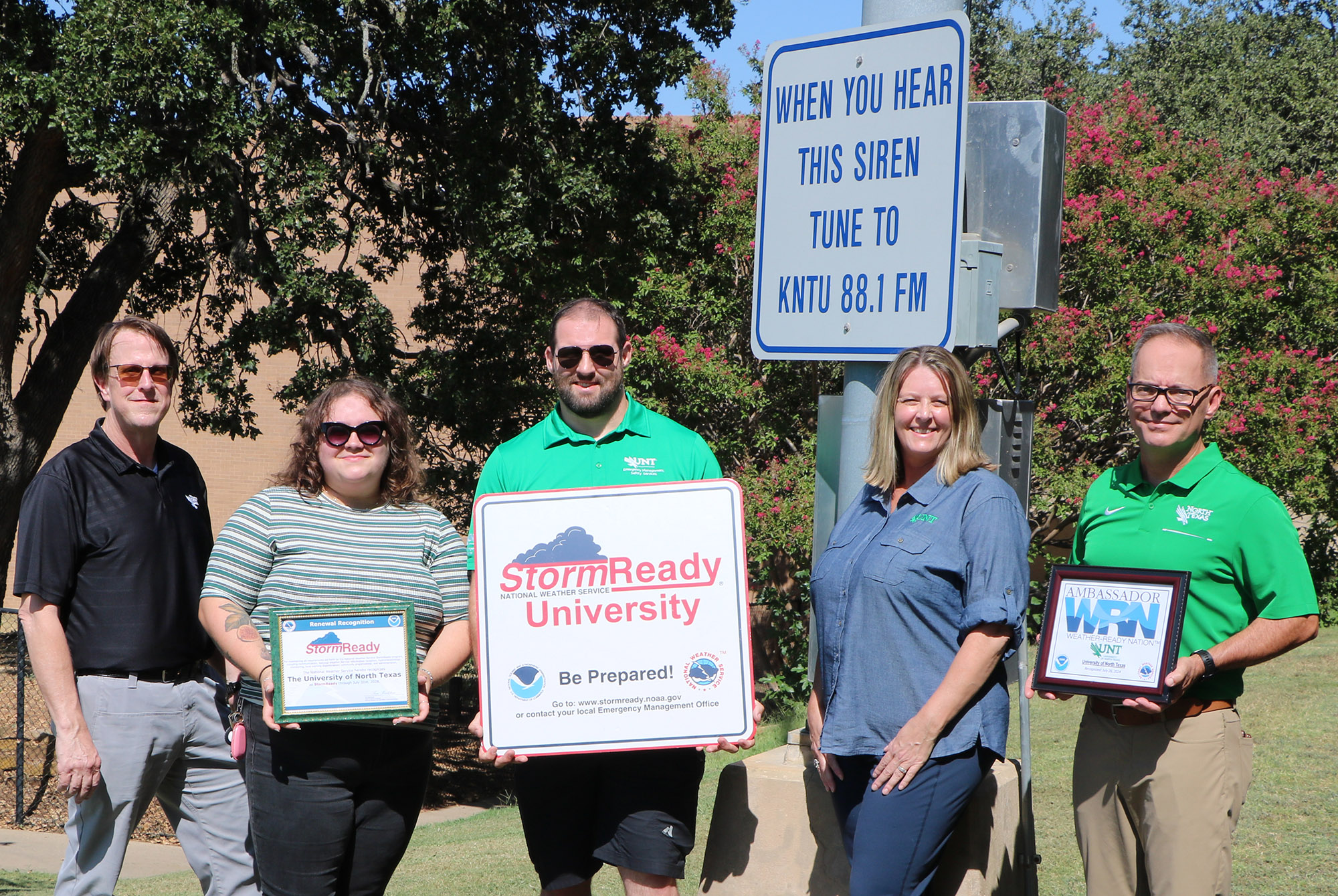 Staff members from Emergency Management and Safety Services holding their Storm Ready sign